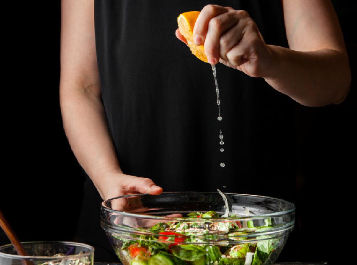 come spremi i limoni probabilmente woman squeezing lemon into chunky salad side view 176474 5547