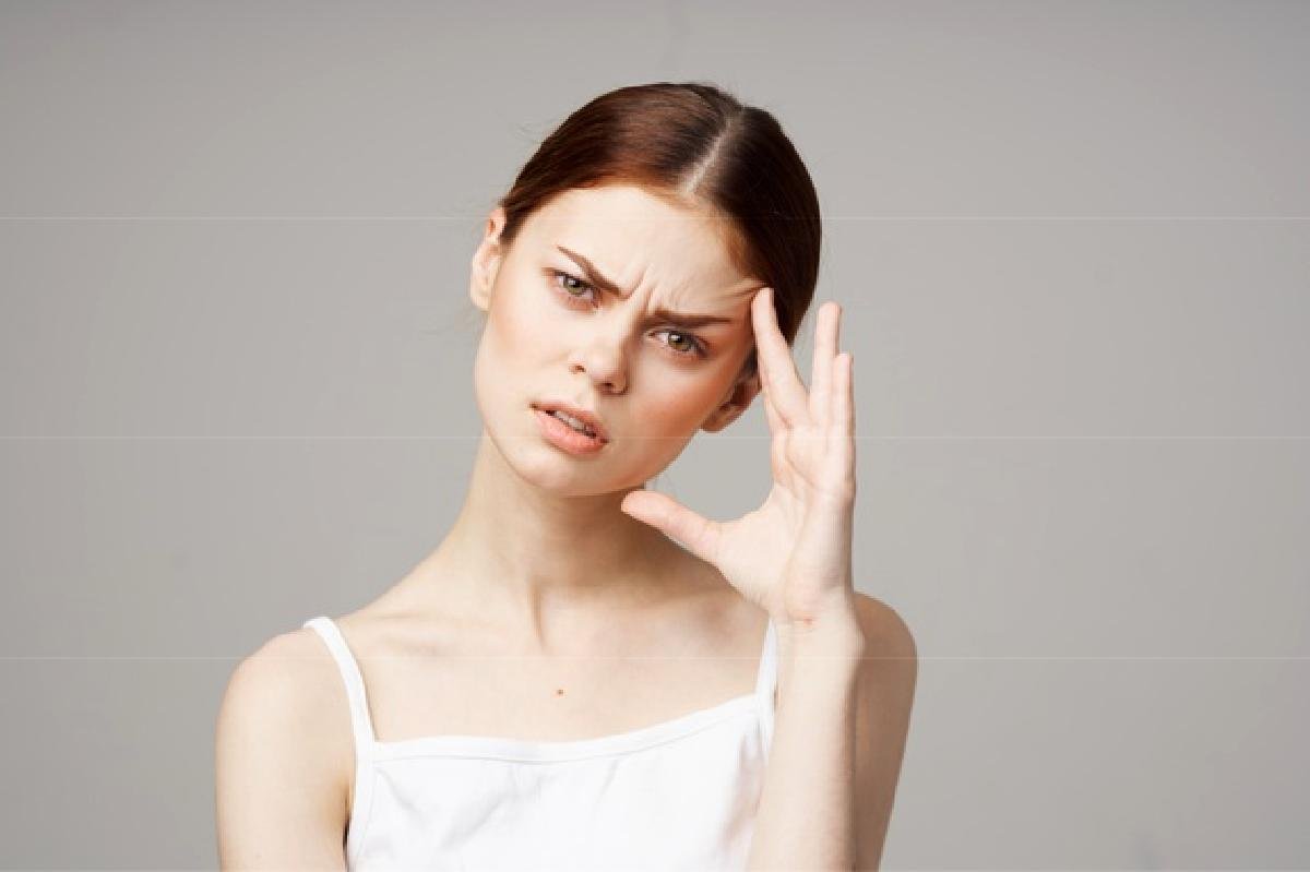 come combattere il mal di headache woman white t shirt touching face with hands health problems 163305 57076